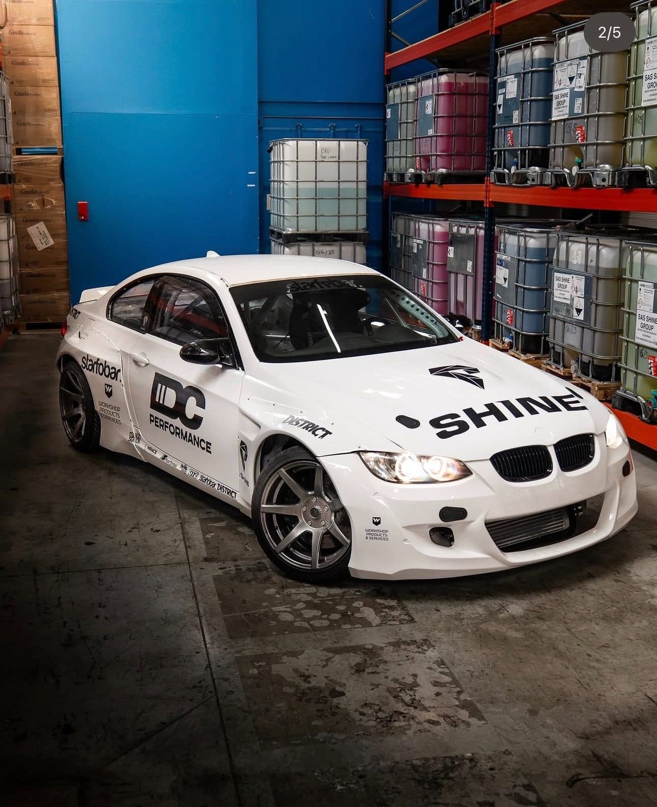 BMW blanche en livrée complète Shine et IDC Performance dans un atelier