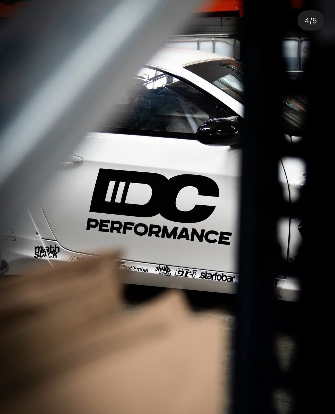 Lettrage IDC Performance découpé posé sur la portière d'une voiture blanche