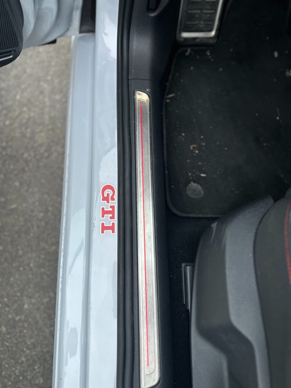 Sticker GTI rouge posé sur le seuil de porte d'une Volkswagen Golf